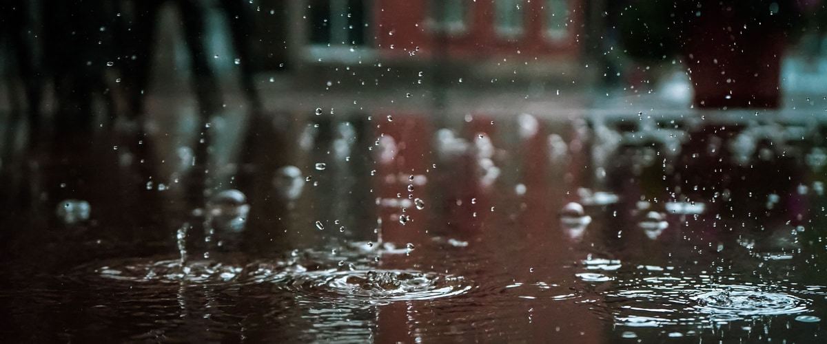 Rain over estate rooftops at evening